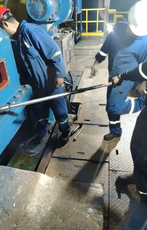 Dos técnicos apretando con llave larga