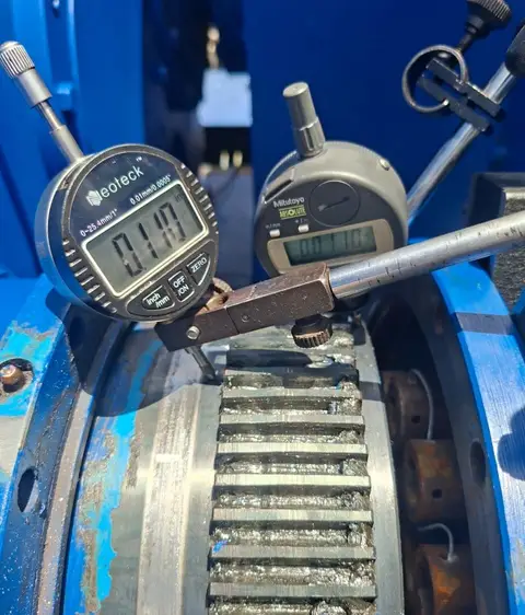 Dos relojes comparadores sobre los dientes de un engranaje