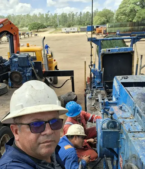 Técnico con la cuadrilla y el camión del taladro
