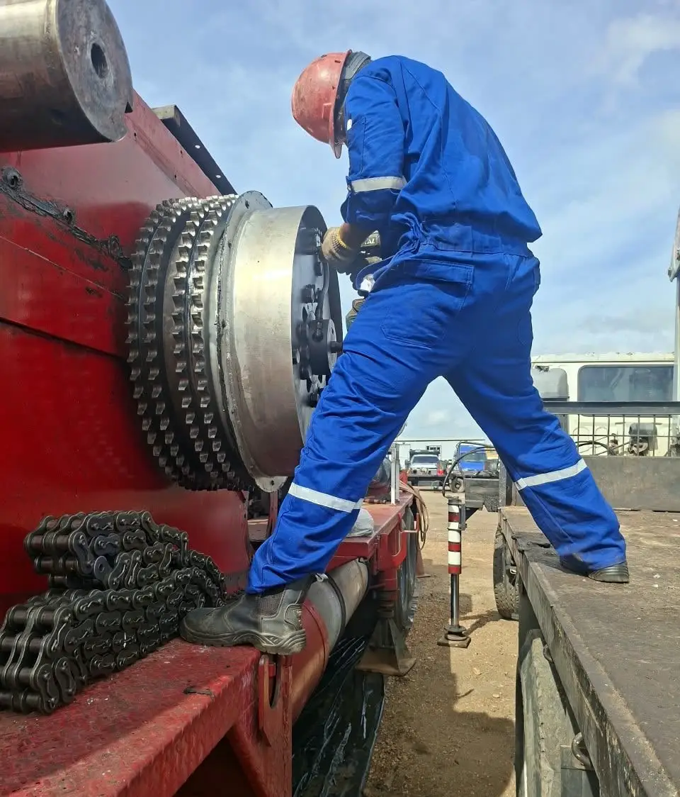 Técnico sobre el camión, junto al piñón de cadenas