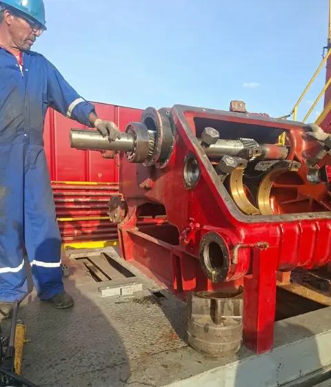 Técnico junto a la caja del cigüeñal, con eje y rodamientos