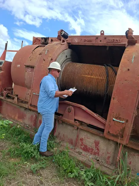 Inspector con su planilla frente al malacate, en campo